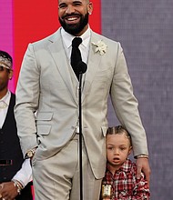 Drake accepts the artist of the decade award as he hugs his son Adonis Graham.