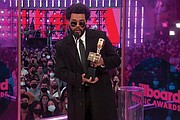 The Weeknd accepts the top artist award.