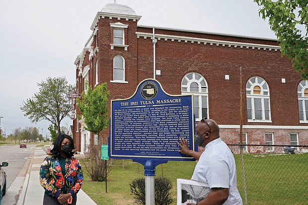 Tiffany Crutcher, left, and Chief Egunwale Amusan talk about a sign commemorating Tulsa’s original Black Wall Street during a tour on April 12.