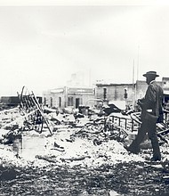A man looks over the remains of buildings after the attack on Tulsa's Greenwood neighborhood in 1921. From the ashes of the Tulsa Star rose the Oklahoma Eagle. (Oklahoma Historical Society/TNS)