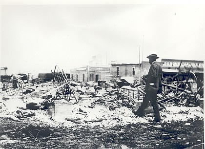 A man looks over the remains of buildings after the attack on Tulsa's Greenwood neighborhood in 1921. From the ashes of the Tulsa Star rose the Oklahoma Eagle. (Oklahoma Historical Society/TNS)