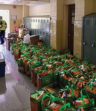 Tote bags filled with food and staples line the hall of Quioccasin Middle School, where volunteers with ICNA Relief and Henrico County Public Schools helped distribute them Saturday to more than 100 families in need who picked up the bags curbside.