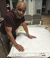 Painting contractor William Bullock looks over documents from the River City Middle School project in his office on Hull Street.