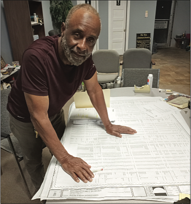 Painting contractor William Bullock looks over documents from the River City Middle School project in his office on Hull Street.