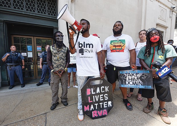 Lawrence West, a founder of BLM RVA, uses a bullhorn to ensure the voices of demonstrators are heard on Tuesday outside the Virginia Supreme Court building on 9th Street in Downtown. The group wants the statue of Confederate Gen. Robert E. Lee removed from Monument Avenue and held a rally and march outside the court during oral arguments in cases involving the statue’s removal.