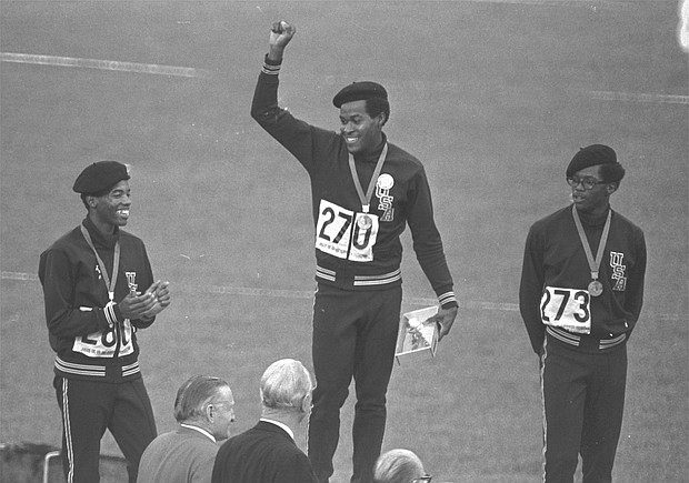 U.S. Olympic team sprinter Lee Evans, center, puts his fist up in a Black Power salute and protest against racism during the medal ceremony at the 1968 Summer Olympics in Mexico City. He and teammates Larry James, left, and Ron Freeman also wore black berets in protest while receiving their medals in the 400-meter race. Evans’ gold medal win in running 400 meters in 43.86 seconds set a record that stood until 1988.