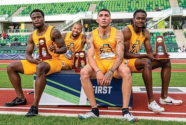 North Carolina A&T State University sprinters, from left, Akeem Sirleaf, Trevor Stewart, Daniel Stokes and Randolph Ross Jr. show off their trophies from winning the 4x400 meter relay last weekend at the NCAA Outdoor Track and Field Championships in Oregon.