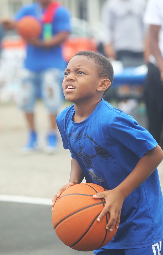 New court in Church Hill/Dallas Ashford, 8, who has his eye on the hoop as he focuses to take a shot.is on the newly unveiled basketball court behind Mt. Olivet Church at 1223 N. 25th St. in Church Hill. Team Loaded and FeedTheStreetsRVA partnered to bring “Operation Homebase” to the area last Saturday, which included unveiling the court and giving new shoes and T-shirts to youths and providing activities and food at the free community gathering.