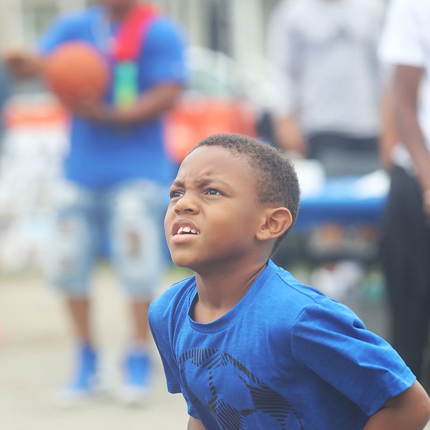 New court in Church Hill/Dallas Ashford, 8, who has his eye on the hoop as he focuses to take a shot.is on the newly unveiled basketball court behind Mt. Olivet Church at 1223 N. 25th St. in Church Hill. Team Loaded and FeedTheStreetsRVA partnered to bring “Operation Homebase” to the area last Saturday, which included unveiling the court and giving new shoes and T-shirts to youths and providing activities and food at the free community gathering.