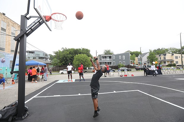 New court in Church Hill/ Christian Ballard, 9, shows off his skills on the newly unveiled basketball court behind Mt. Olivet Church at 1223 N. 25th St. in Church Hill. Team Loaded and FeedTheStreetsRVA partnered to bring “Operation Homebase” to the area last Saturday, which included unveiling the court and giving new shoes and T-shirts to youths and providing activities and food at the free community gathering.