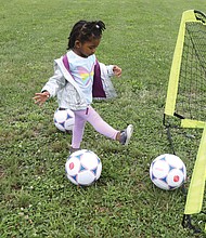 Budding athlete/Tajiya Taper, 2, of Henrico County has fun trying to get the soccer balls into the goal set up last Saturday at Mt. Olivet Church in Church Hill for Operation Homebase. The youngster was attending the event with her grandparents, Nicole and Rodney Gore with the Team Loaded Foundation.