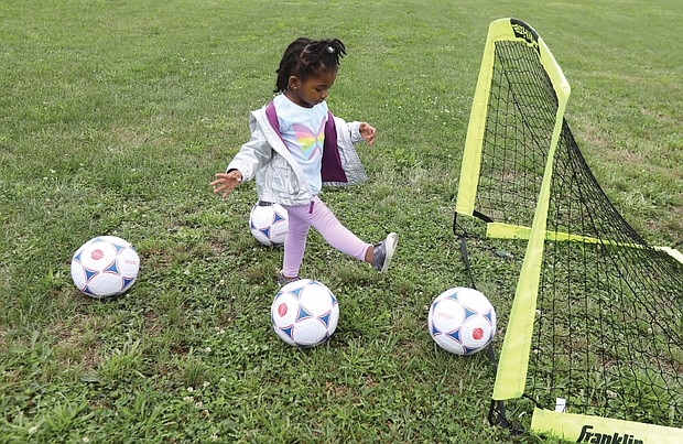 Budding athlete/Tajiya Taper, 2, of Henrico County has fun trying to get the soccer balls into the goal set up last Saturday at Mt. Olivet Church in Church Hill for Operation Homebase. The youngster was attending the event with her grandparents, Nicole and Rodney Gore with the Team Loaded Foundation.