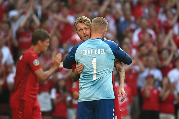 Simon Kjaer and Kasper Schmeichel of Denmark interact as the ball is kicked out of play in the tenth minute followed by a minute of applause in support of Denmark International Christian Eriksen.
Mandatory Credit: Jonathan Nackstrand/Pool/Getty Images