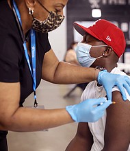 Yaw Kesse gets a COVID-19 vaccine from Alexis Watts at Guaranteed Rate Field before the start of the Chicago White Sox game against the Toronto Blue Jays on June 8.
Mandatory Credit:	Scott Olson/Getty Images