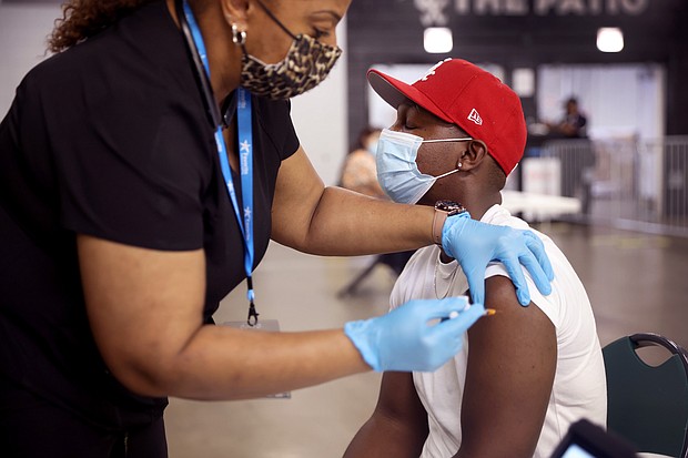 Yaw Kesse gets a COVID-19 vaccine from Alexis Watts at Guaranteed Rate Field before the start of the Chicago White Sox game against the Toronto Blue Jays on June 8.
Mandatory Credit:	Scott Olson/Getty Images
