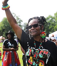 Claudia Clarke raises her fist in a show of support and solidarity with the messages delivered by local leaders at the “Love and Legacy Juneteenth Jubilee Celebration” at the Landing at Fountain Lake in Byrd Park  The event, organized by Sherri Robinson of ShowLove LLC, featured music, dance, entertainment, children’s activities and information about community resources.