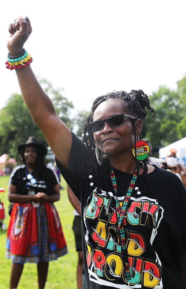 Claudia Clarke raises her fist in a show of support and solidarity with the messages delivered by local leaders at the “Love and Legacy Juneteenth Jubilee Celebration” at the Landing at Fountain Lake in Byrd Park  The event, organized by Sherri Robinson of ShowLove LLC, featured music, dance, entertainment, children’s activities and information about community resources.