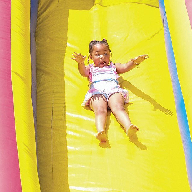 People of all ages enjoyed live music, including the sounds of Plunky Branch, food, games and activities for youngsters, historical interpreters and a car club expo at Juneteenth at Dorey Park in Eastern Henrico County. Four-year-old Milaya Woodly glides down a giant slide.