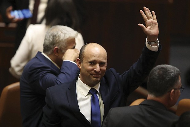 Israel’s new Prime Minister Naftali Bennett raises his hand during a Knesset session June 13 in Jerusalem. Israel’s parliament has voted in favor of a new coalition government, formally ending Prime Minister Benjamin Netanyahu’s historic 12-year rule.