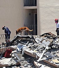 Search and rescue personnel search for survivors through the rubble with their dogs at the Champlain Towers South in Surfside, Florida on June 27.
Mandatory Credit:	David Santiago/AP