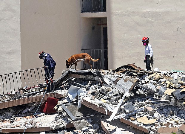 Search and rescue personnel search for survivors through the rubble with their dogs at the Champlain Towers South in Surfside, Florida on June 27.
Mandatory Credit: David Santiago/AP