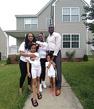 Travis L. and Latarsha F. Woods and their three children stand outside their home in Richmond’s Fulton neighborhood.