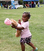 A real sweetie/Amira Jones, 3, has her hands full with a teddy bear and cotton candy at the recent Community Outreach Day at Hotchkiss Field Community Center in North Side. The free event was sponsored by Project Restore, Empowering Youth for Positive Change and the Capital Area Health Network.