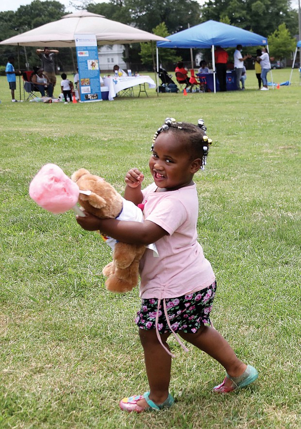 A real sweetie/Amira Jones, 3, has her hands full with a teddy bear and cotton candy at the recent Community Outreach Day at Hotchkiss Field Community Center in North Side. The free event was sponsored by Project Restore, Empowering Youth for Positive Change and the Capital Area Health Network.