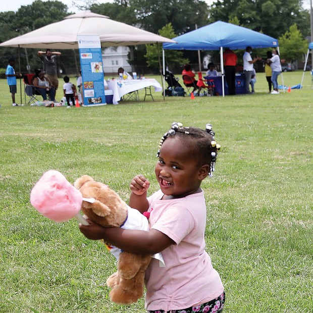 A real sweetie/Amira Jones, 3, has her hands full with a teddy bear and cotton candy at the recent Community Outreach Day at Hotchkiss Field Community Center in North Side. The free event was sponsored by Project Restore, Empowering Youth for Positive Change and the Capital Area Health Network.