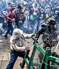 Demonstrators clash with riot police during a protest against a tax reform bill launched by Colombian President Ivan Duque, in Bogota, on April 28.
Mandatory Credit:	Juan Barreto/AFP via Getty Images