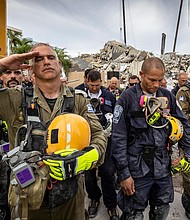 Members of search and rescue teams gather for a moment of silence and prayer at the memorial to the victims in the collapsed 12-story Champlain Towers South condo building.
Mandatory Credit:	Jose A Iglesias/Pool/Getty Images