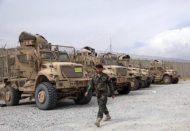 An Afghan army soldier walks past Mine Resistant Ambush Protected vehicles that were left after the American military left Bagram air base, north of Kabul, Afghanistan, on July 5.
Mandatory Credit:	Rahmat Gul/AP