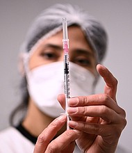 A health worker prepares a syringe with the Pfizer/BioNTech Covid-19 vaccine on January 6, in Aulnay-sous-Bois.
Mandatory Credit:	Christophe Archambault/Pool/Getty Images