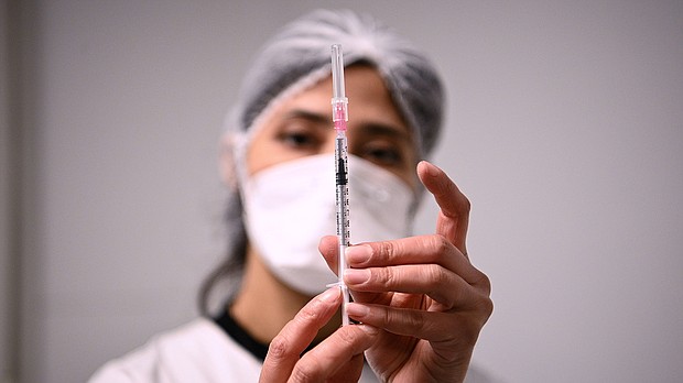 A health worker prepares a syringe with the Pfizer/BioNTech Covid-19 vaccine on January 6, in Aulnay-sous-Bois.
Mandatory Credit:	Christophe Archambault/Pool/Getty Images