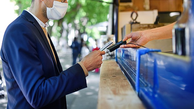 A man pays at a coffee stall. The US economy is showing signs of recovery. That could also mean spending more money on activities that people may not have done in a while -- like going to the movies, dining out or taking a vacation.
Mandatory Credit: Halfpoint Images/Moment RF/Getty Images