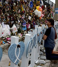 People pray at the memorial to the victims of the collapsed Champlain Towers South condo building following a severe thunderstorm on July 12.
Mandatory Credit:	Anna Moneymaker/Getty Images