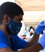A health care worker prepares a dose of the Moderna Covid-19 vaccine during a Kedren Health mobile vaccine clinic at the Watts Juneteenth Street Fair on June 19 in the Watts neighborhood of Los Angeles, California.
Mandatory Credit:	Patrick T. Fallon/AFP/Getty Images