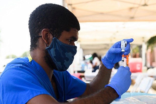 A health care worker prepares a dose of the Moderna Covid-19 vaccine during a Kedren Health mobile vaccine clinic at the Watts Juneteenth Street Fair on June 19 in the Watts neighborhood of Los Angeles, California.
Mandatory Credit:	Patrick T. Fallon/AFP/Getty Images