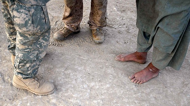 A U.S. Marine (C) talks through his interpreter (L) to an Afghan man during a patrol on July 6, 2009 in Mian Poshteh, Afghanistan.
Mandatory Credit:	Joe Raedle/Getty Images