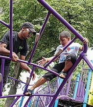 Fun with Dad/Rashe Peoples Jr., 6, takes on the challenge of climbing on playground equipment with the knowledge his dad, Rashe Peoples, has his back. The father and son enjoyed time together last Saturday at Abner Clay Park in Jackson Ward.