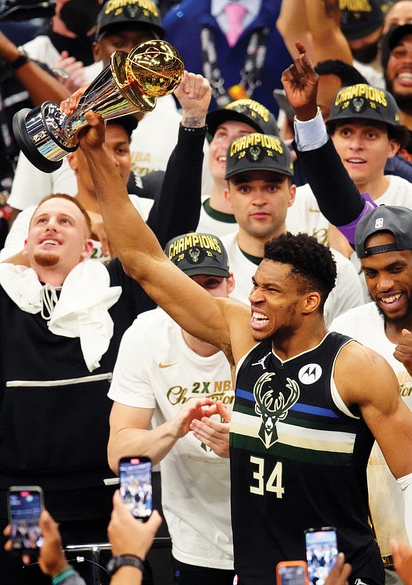 Giannis Antetokounmpo had the Larry O’Brien Trophy in one arm, the NBA Finals MVP trophy in the other and there ...