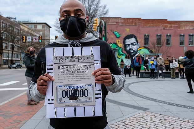 Reginald Carter gathers signatures for his proposed Richmond Planet license plate during a rally earlier this year in Downtown at Adams and Broad streets where a mural of longtime Richmond Planet editor John Mitchell Jr. is located.