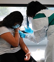 Jenna Ramkhelawan, 12, receives the Pfizer Covid-19 vaccine in Miami. Every one of Florida and Arkansas counties is now listed as having "high" levels of community transmission, according to data from the US Centers for Disease Control and Prevention.
Mandatory Credit:	Marta Lavandier/AP