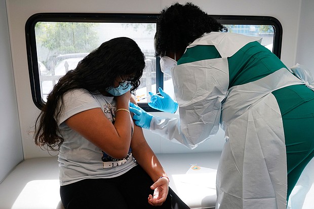 Jenna Ramkhelawan, 12, receives the Pfizer Covid-19 vaccine in Miami. Every one of Florida and Arkansas counties is now listed as having "high" levels of community transmission, according to data from the US Centers for Disease Control and Prevention.
Mandatory Credit:	Marta Lavandier/AP