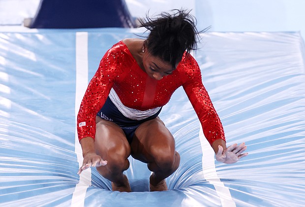 Simone Biles of Team United States stumbles upon landing after competing in vault during the women's team final on day four of the Tokyo 2020 Olympic Games at Ariake Gymnastics Centre.
Mandatory Credit:	Jamie Squire/Getty Images