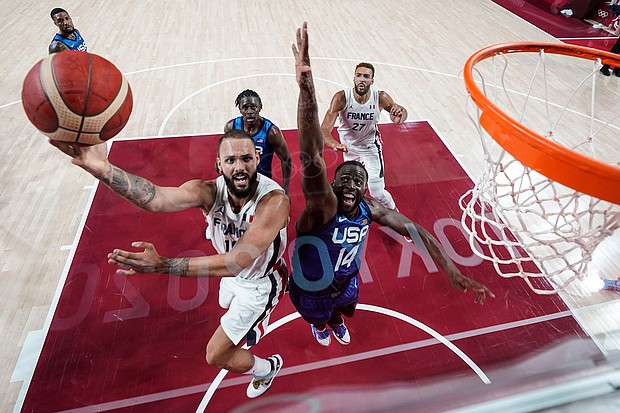 France's Evan Fournier goes for the basket past USA's Draymond Green at the Saitama Super Arena in Saitama, Japan, on July 25.
Mandatory Credit:	Eric Gay/AFP/Getty Images