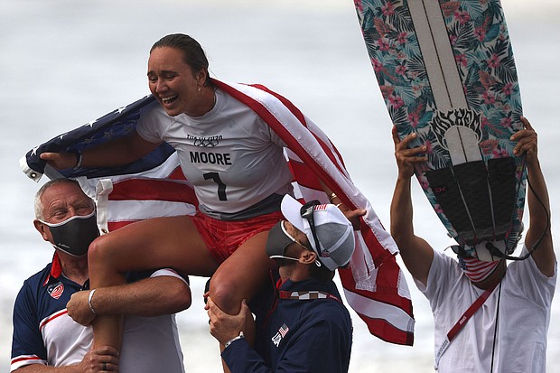 US's Carissa Moore celebrates after winning the women's Surfing gold medal final at the Tsurigasaki Surfing Beach, in Chiba, on July 27, during the Tokyo 2020 Olympic Games.
Mandatory Credit:	Yuki Iwamura/AFP/Getty Images