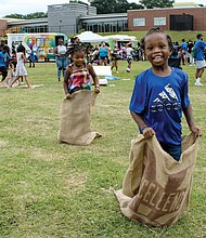 Fun at RPS Summer Fest/Gerald Brown, 5, outdistances his 4-year-old sister, Gabrielle, during a sack race last Saturday at Martin Luther King Jr. Middle School during RPS Summer Fest. The event, sponsored by Richmond Public Schools, provided information for families on how to enroll students for the upcoming school year, while offering music, entertainment, art stations, books and refreshments.