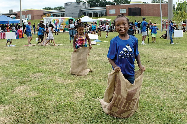 Fun at RPS Summer Fest/Gerald Brown, 5, outdistances his 4-year-old sister, Gabrielle, during a sack race last Saturday at Martin Luther King Jr. Middle School during RPS Summer Fest. The event, sponsored by Richmond Public Schools, provided information for families on how to enroll students for the upcoming school year, while offering music, entertainment, art stations, books and refreshments.