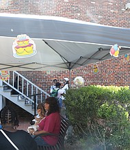 Happy Birthday, Mrs. Walker! Richmond area residents took time recently to remember pioneering Richmond businesswoman Maggie L. Walker in honor of what would have been her 157th birthday on July 15. While she is best known as the first Black woman to found and serve as president of a bank in the United States, she also was a civil rights and voting rights advocate, newspaper publisher, store owner and politician and all around community leader.  Her home at 110 ½ E. Leigh St. is a national historic site run by the National Park Service, which held a public celebration of Mrs. Walker’s birthday July 17 in the courtyard behind her home and the NPS visitors’ center on the site at 600 N. 2nd St.  Samuel L. Houston, 11, of Short Pump enjoys a birthday celebration cupcake in the courtyard, where he joined with his parents, Pamela and Cedric Houston, to learn about Mrs. Walker and her legacy.